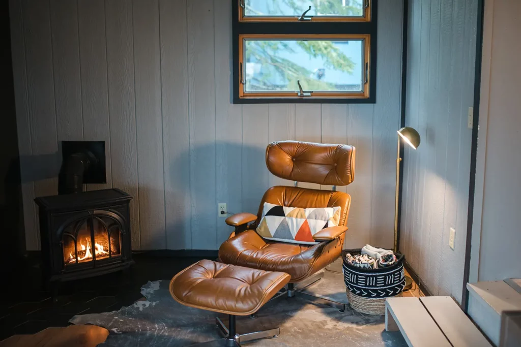 eames lounger next to small fireplace in living room